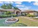 Charming brick home featuring a well-manicured front yard with a lovely statue fountain at 7230 Hileman W Dr, Lakeland, FL 33810