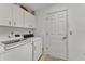 A laundry room with modern washer and dryer along with white cabinets at 7230 Hileman W Dr, Lakeland, FL 33810