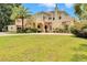 Elegant home boasts arched entryway, lush lawn, vibrant landscaping, and classic architectural details at 845 E Edgewood Dr, Lakeland, FL 33803