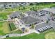 Aerial view of golf course amenities, including the clubhouse, golf carts, and putting greens at 1010 Penguin Pl, Lakeland, FL 33809