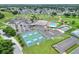Aerial view of Sandpiper Golf & Country Club's clubhouse, pool, and tennis and pickle ball courts at 1010 Penguin Pl, Lakeland, FL 33809
