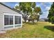 A view of the backyard that has green grass, a back porch, and ample room for outdoor activities at 1010 Penguin Pl, Lakeland, FL 33809