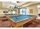 A billiard room with two pool tables, including pendant lighting and large windows at 1010 Penguin Pl, Lakeland, FL 33809
