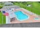 Aerial view of a community pool with plenty of lounge chairs, a hot tub, and a seating area under a canopy at 1010 Penguin Pl, Lakeland, FL 33809