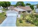 Charming home with mature trees, a well-kept lawn, and an attached two-car garage at 1010 Penguin Pl, Lakeland, FL 33809