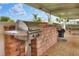 Community grill area with brick facade, picnic seating, and a ceiling fan at 1010 Penguin Pl, Lakeland, FL 33809