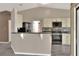 Open kitchen with a breakfast bar, white cabinets, black appliances, and wood-look flooring at 1010 Penguin Pl, Lakeland, FL 33809
