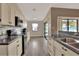 Bright kitchen with white cabinets, black appliances, stone backsplash, and wood-look flooring at 1010 Penguin Pl, Lakeland, FL 33809