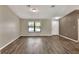 Spacious living room featuring new dark vinyl floors, neutral paint, and a bright window at 1010 Penguin Pl, Lakeland, FL 33809