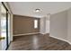 Open living room with wood-look flooring and sliding glass doors leading to the lanai at 1010 Penguin Pl, Lakeland, FL 33809