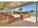 Outdoor seating area with brick walls and picnic tables beneath a covered patio next to the tennis courts at 1010 Penguin Pl, Lakeland, FL 33809