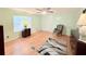 Well-lit bedroom featuring wood-look floors, an accent chair, neutral paint, and a ceiling fan at 1011 Pine Ridge Dr, Lakeland, FL 33809