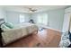 Large bedroom featuring wood-look floors, two windows, a ceiling fan, and neutral paint at 1011 Pine Ridge Dr, Lakeland, FL 33809