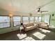 Sunlit living room featuring two sofas, multiple windows with blinds, and a ceiling fan at 1011 Pine Ridge Dr, Lakeland, FL 33809