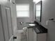 Bathroom with a white vanity, black granite countertop, and a framed mirror at 1014 Lexington St, Lakeland, FL 33801