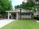 Gray exterior home with large front yard, covered parking, and manicured landscaping at 1014 Lexington St, Lakeland, FL 33801