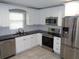 Bright kitchen with stainless steel appliances, white cabinetry, and black countertops at 1014 Lexington St, Lakeland, FL 33801