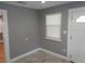 Clean, neutral room with a window with blinds and a white door with decorative window at 1014 Lexington St, Lakeland, FL 33801