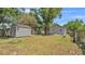 Spacious backyard with a storage shed, mature trees, and a partial view of the house at 1105 Terry S Ave, Lakeland, FL 33815