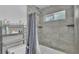 Well-lit bathroom with grey tile walls and a walk in shower at 1105 Terry S Ave, Lakeland, FL 33815