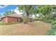 Spacious backyard with a brick home nestled among mature trees at 1205 Scottsland Dr, Lakeland, FL 33813