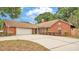 Brick house with two car garage, mature landscaping and craftsman style front door at 1205 Scottsland Dr, Lakeland, FL 33813