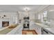 A well-lit kitchen with white cabinetry and stainless steel appliances adjoins a cozy fireplace at 1205 Scottsland Dr, Lakeland, FL 33813