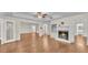 Bright open-concept living room featuring hardwood floors, a fireplace, and a white color palette at 1205 Scottsland Dr, Lakeland, FL 33813