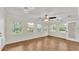 Sunlit living room featuring a ceiling fan, multiple windows, and wood flooring at 1205 Scottsland Dr, Lakeland, FL 33813