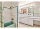 Bathroom with shower/tub combo with green tile, vanity, and a vintage mirror with lights at 1407 Easton Dr, Lakeland, FL 33803