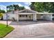 Exterior view shows the driveway, carport, partial fencing and neutral paint at 1407 Easton Dr, Lakeland, FL 33803