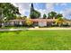 Charming single-story home with a red roof, lush landscaping, and a brick driveway at 1407 Easton Dr, Lakeland, FL 33803