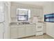 Functional kitchen featuring white cabinets, matching appliances, and a double stainless steel sink at 1407 Easton Dr, Lakeland, FL 33803
