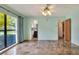 Bright living room featuring tile floors, ceiling fan, a large window and adjacent bathroom at 1407 Easton Dr, Lakeland, FL 33803