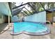The enclosed pool features clear water, metal railing, and tile patio in the backyard at 1407 Easton Dr, Lakeland, FL 33803