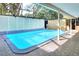 The enclosed swimming pool features clear water, a geometric design and surrounding lattice enclosure at 1407 Easton Dr, Lakeland, FL 33803