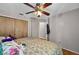 A bedroom features hardwood floors, a ceiling fan, closet, and access to another room at 1573 Avleigh Cir, Orlando, FL 32824