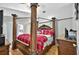Spacious bedroom featuring a wooden four-poster bed with red and white checkered bedding at 1573 Avleigh Cir, Orlando, FL 32824