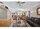 Open living room with hardwood floors, leather couch, and views into dining and kitchen areas at 1573 Avleigh Cir, Orlando, FL 32824