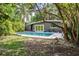 Backyard featuring a swimming pool, dark grey home exterior, and tropical landscaping at 1604 Sylvester Rd, Lakeland, FL 33803