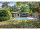 Backyard featuring a swimming pool, dark grey home exterior, and tropical landscaping at 1604 Sylvester Rd, Lakeland, FL 33803