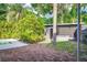 Backyard pool area with brick patio, privacy landscaping, and view of adjacent building at 1604 Sylvester Rd, Lakeland, FL 33803