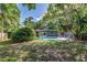 Backyard oasis featuring a sparkling pool, lush tropical landscaping, and lounge seating area at 1604 Sylvester Rd, Lakeland, FL 33803