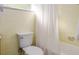 This bathroom has cream-colored tiles, a white toilet, and a white shower curtain at 1604 Sylvester Rd, Lakeland, FL 33803