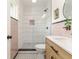 Bathroom featuring a step-in shower, vertical white tiles and pink accents, and stylish vanity at 1604 Sylvester Rd, Lakeland, FL 33803