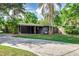 Spacious carport of a modern single-story home with well-maintained lawn and mature trees, providing ample parking at 1604 Sylvester Rd, Lakeland, FL 33803