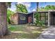 Stylish single-story home featuring brick accent wall, gray siding, well-maintained lawn, and large mature trees at 1604 Sylvester Rd, Lakeland, FL 33803