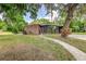 Charming single-story home boasts a brick facade, lush landscaping, a well-manicured lawn, and a welcoming walkway to front door at 1604 Sylvester Rd, Lakeland, FL 33803