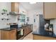 Modern kitchen featuring stainless steel appliances, dark countertop, and floating shelves at 1604 Sylvester Rd, Lakeland, FL 33803
