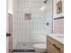 Walk-in shower area with white tiles and pink accents, and an eye-catching mosaic tiled floor at 1604 Sylvester Rd, Lakeland, FL 33803